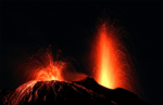 A volcano surges with red lava in the black night - an image of change from Victor via Albumarium