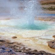 geyser erupting with multiple colors