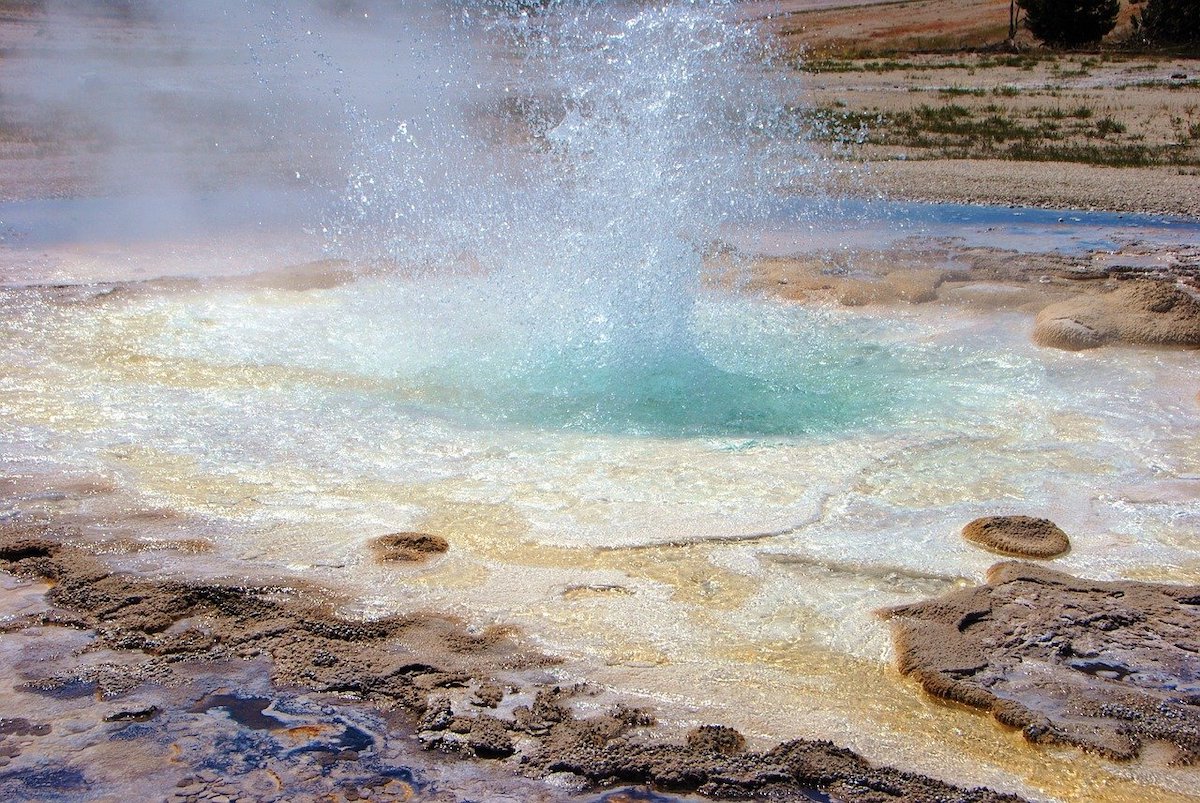 geyser erupting with multiple colors