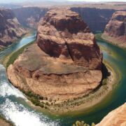 large red rock formation splitting a river into two sides