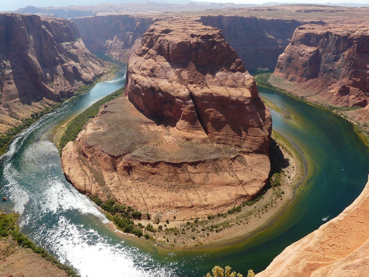 large red rock formation splitting a river into two sides