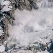 snow avalanche coming down a mountain with force