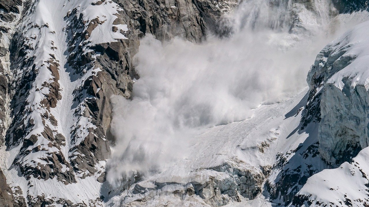 snow avalanche coming down a mountain with force