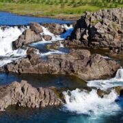 Waterfalls and rocks in a river in Iceland.