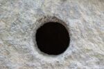 Light gray rock with dark hole in center
