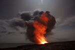 Lava spewing from a volcano with fire and black smoke