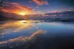 sunrise on water with clouds and reflections