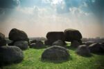 Blue sky and a field with boulders arranged haphazardly
