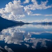 Sky, clouds and mountain reflected in still water.