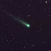 A NASA Agency photo of a comet in space surrounded by stars.