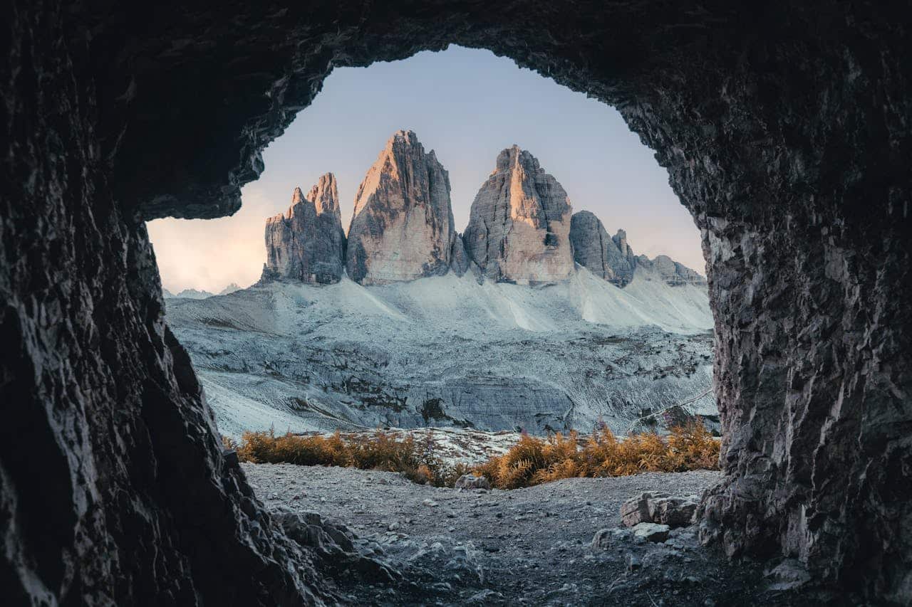 The edge of a cave looking out on a rugged mountainous landscape