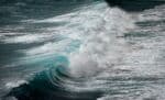 A large, breaking ocean wave - blue water with white caps.