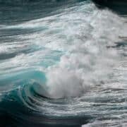 A large, breaking ocean wave - blue water with white caps.