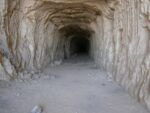 Opening to a cave. Plain gray rock with deep entrance