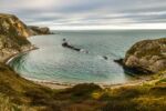 A sheltered ocean cove surrounded with rocks on three sides.