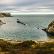 A sheltered ocean cove surrounded with rocks on three sides.