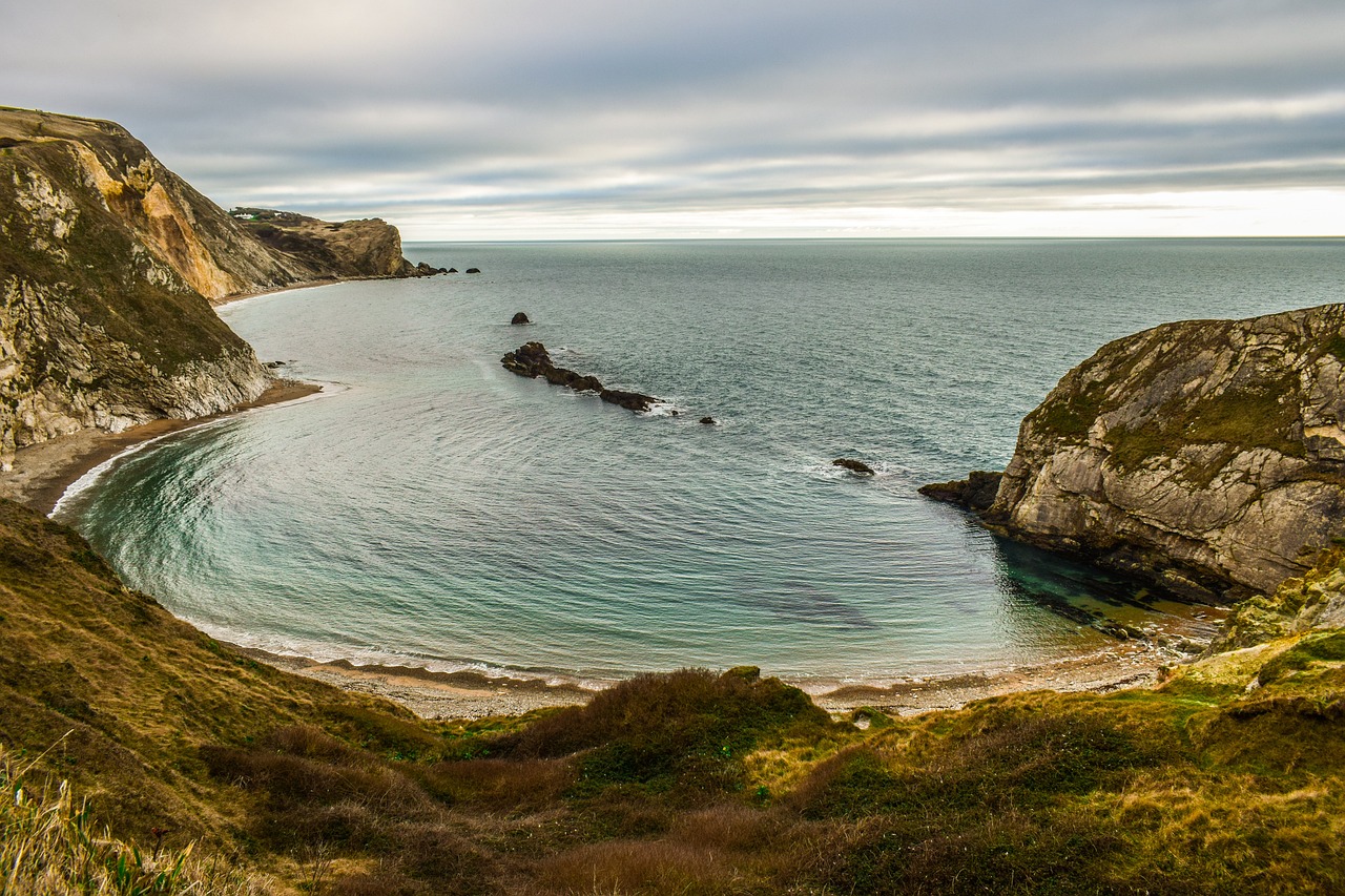 A sheltered ocean cove surrounded with rocks on three sides.