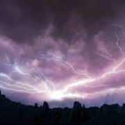 Dramatic lightning in a dark blue and purple sky.