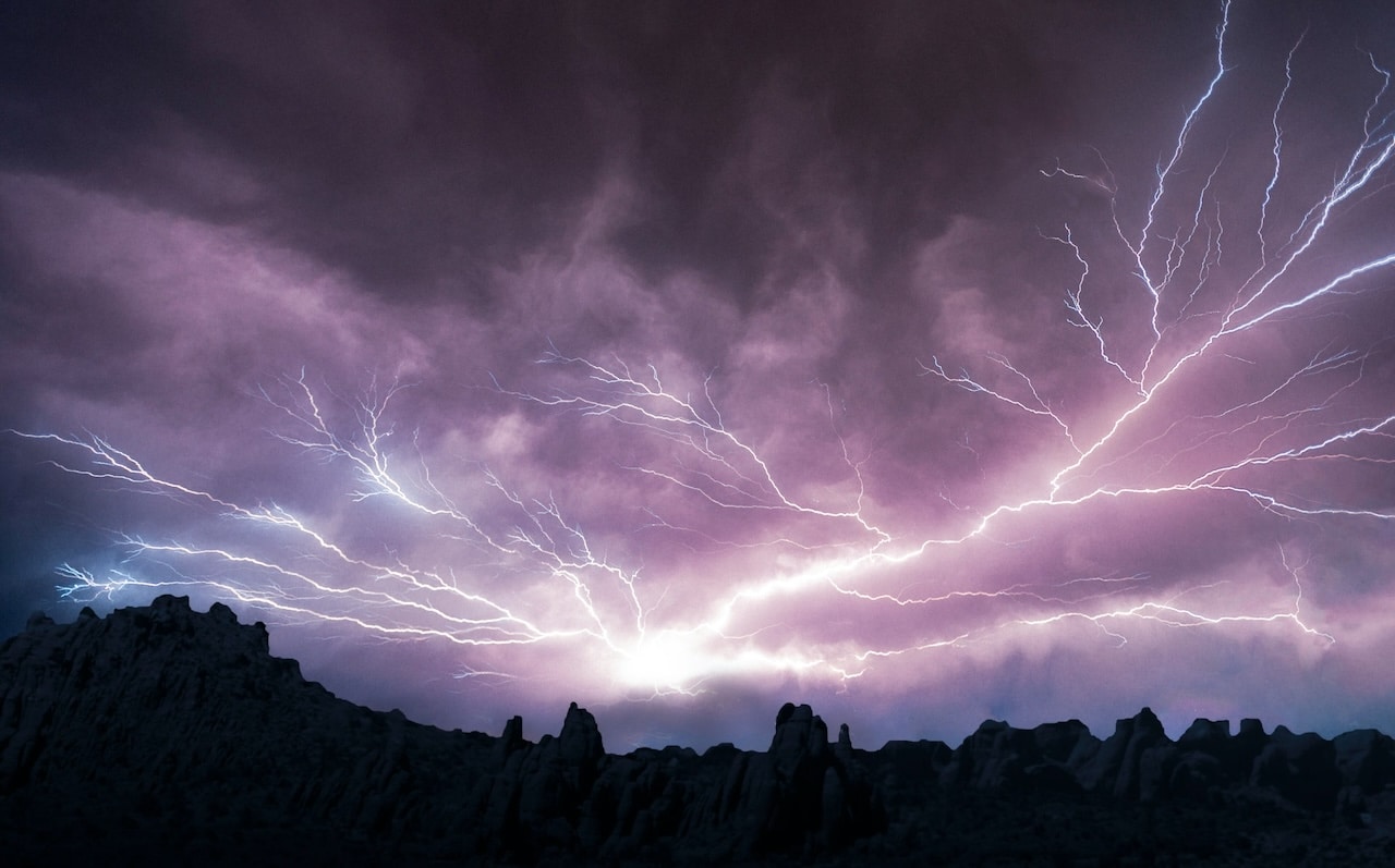 Dramatic lightning in a dark blue and purple sky.
