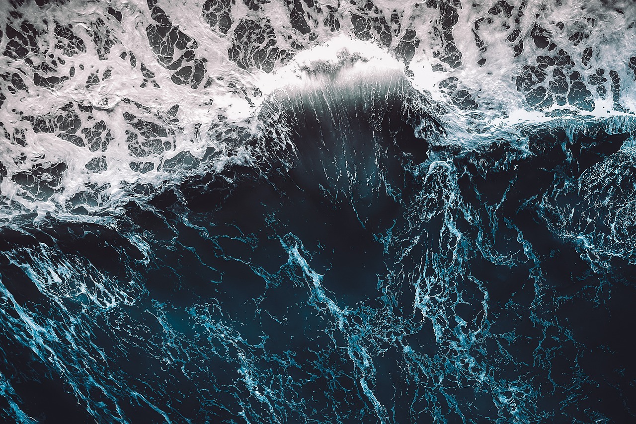 A chaotic, swelling blue ocean wave.