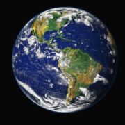 A color photo of earth from space with swirling clouds visible.
