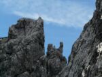 Very jagged and steep gray rocks against a blue sky