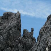 Very jagged and steep gray rocks against a blue sky