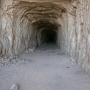 A tannish brown cave opening with a long, dark entryway.