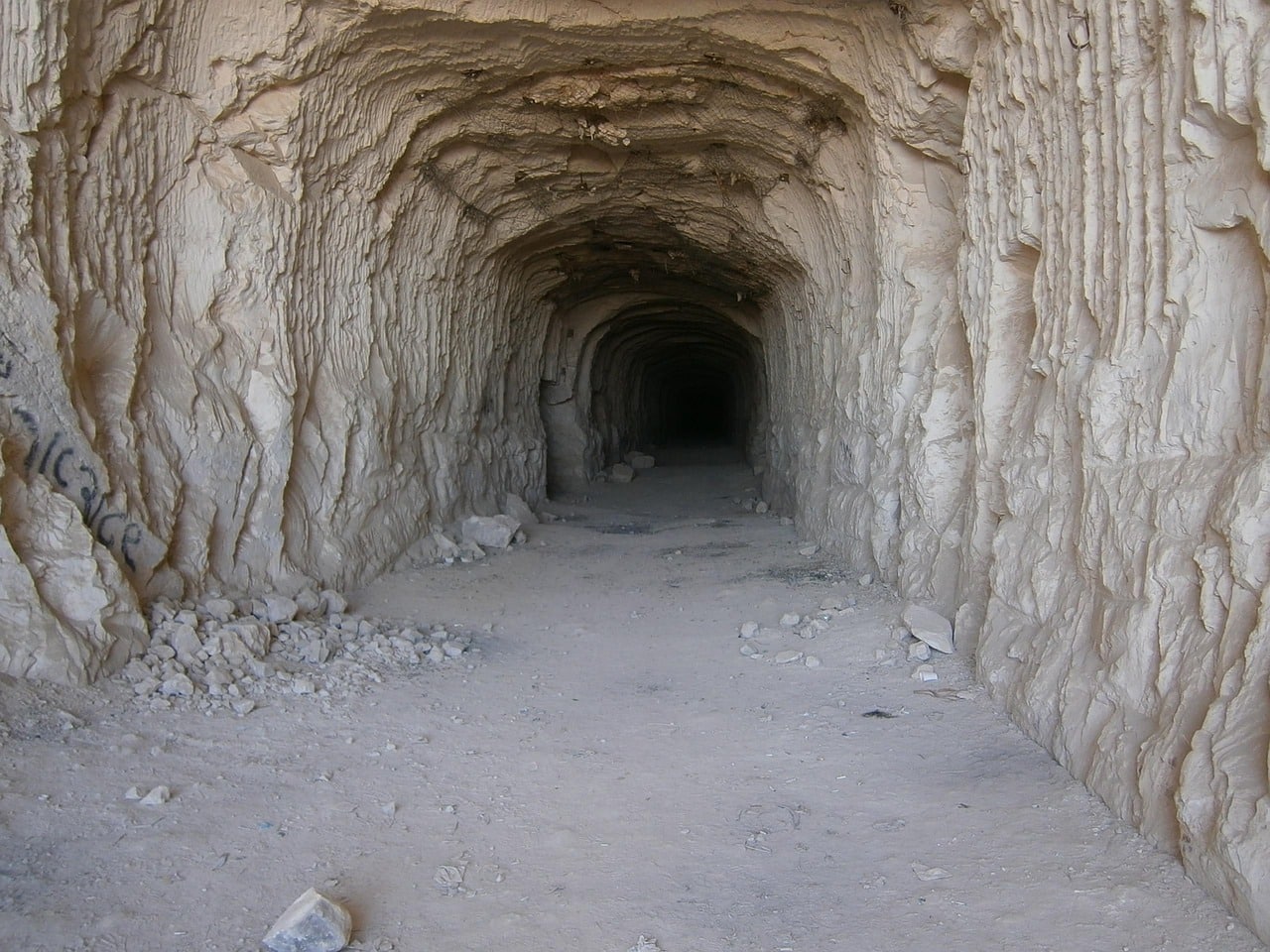 A tannish brown cave opening with a long, dark entryway.