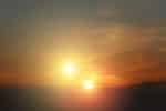 Two bright yellow suns in a brown and orange sky
