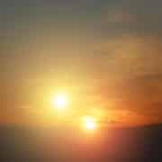 Two bright yellow suns in a brown and orange sky