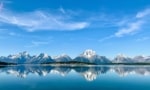 Snow-capped Grand Teton mountain range perfectly reflected in a body of water