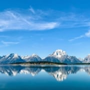 Snow-capped Grand Teton mountain range perfectly reflected in a body of water