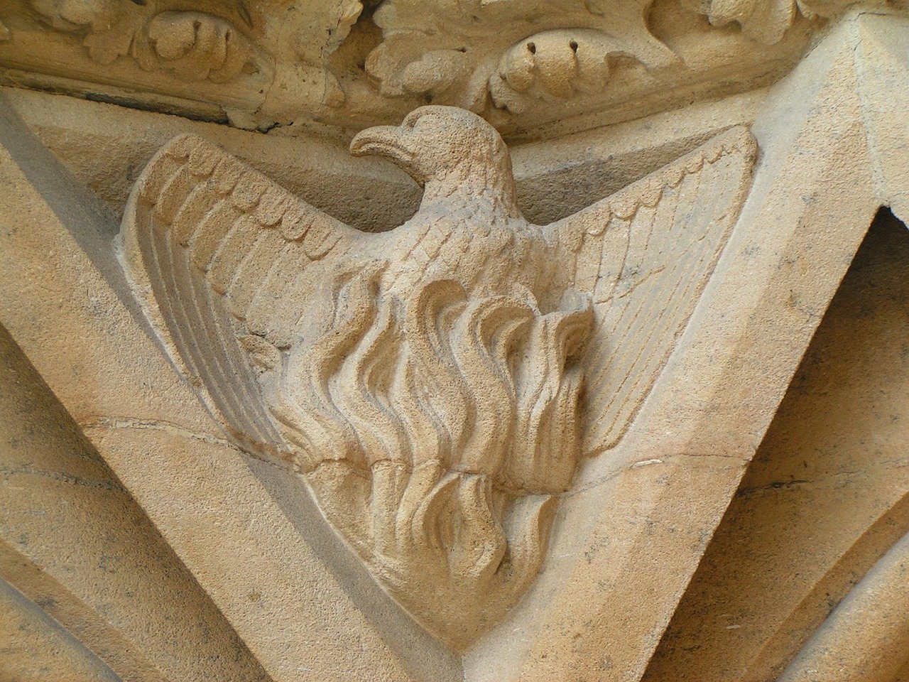 A stone carving of a phoenix on a cathedral.