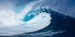 A powerful wave of blue hues and white foam breaking with intensity.