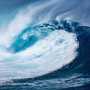 A powerful wave of blue hues and white foam breaking with intensity.