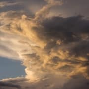 Storm clouds in the sky along with a little sun and blue sky.