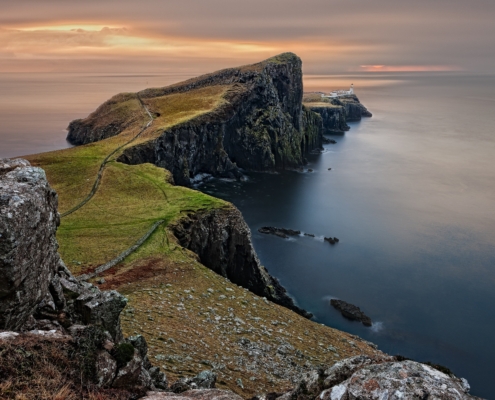 A grass-covered rock peninsula jutting into the ocean.
